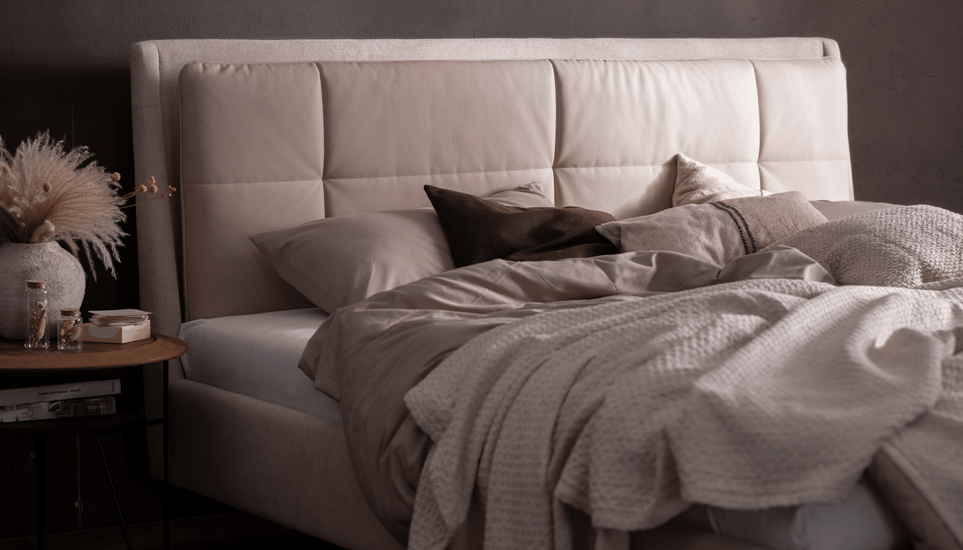 Das Bett Decuro von ADA Mindful Living mit gepolstertem Bettkasten und Kopfteil, das Wendekissen ist aus Leder Das Bett Decuro von ADA Mindful Living mit gepolstertem Bettkasten und Kopfteil, das Wendekissen ist aus Leder