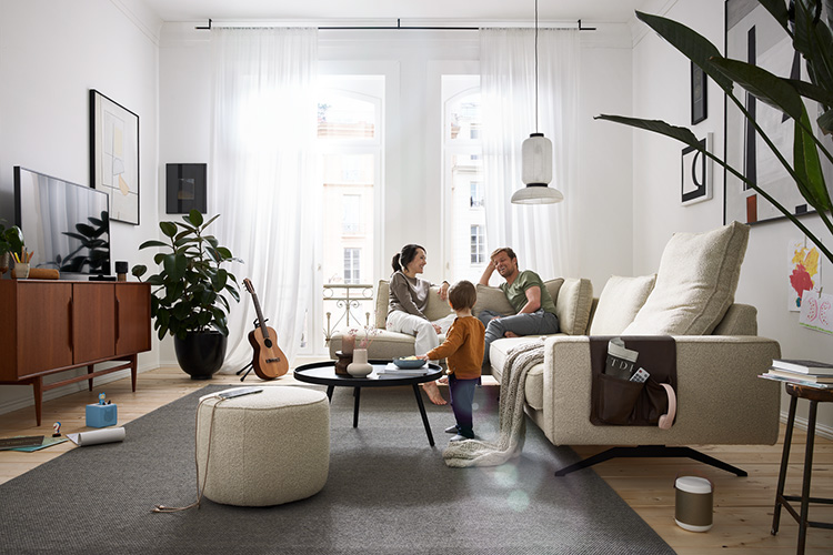 Eltern mit Kind sitzen auf einem hellen Sofa