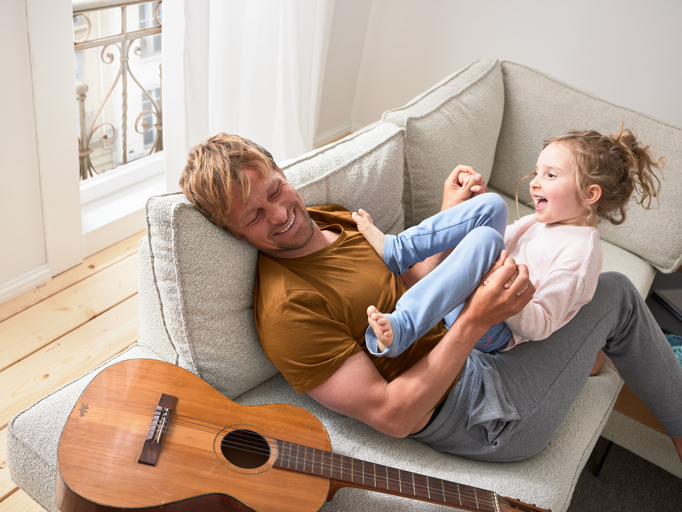 Vater und Tochter spielen auf der Couch