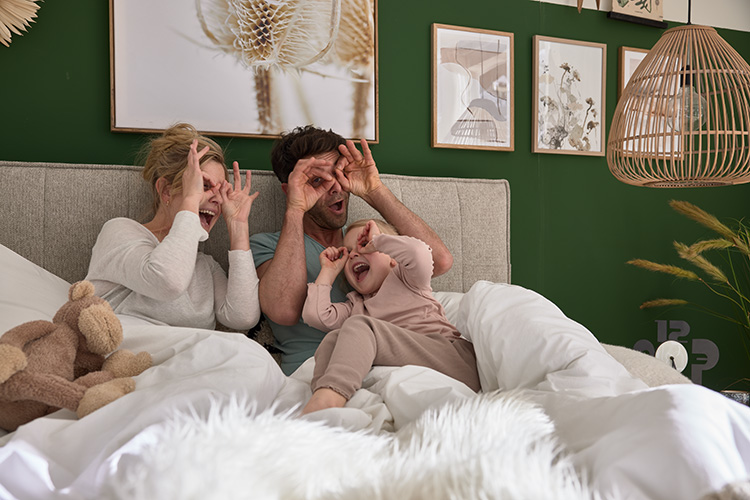 Familie spielt im Boxspringbett Nirina