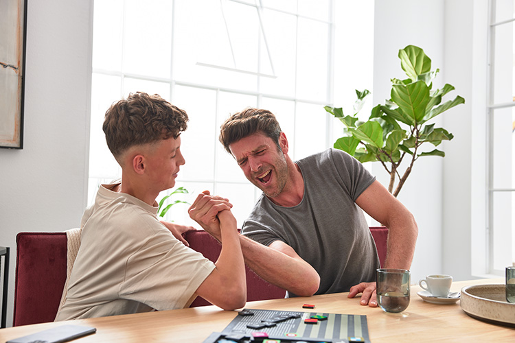 Vater und Sohn beim Armdrücken auf der Essbank Dulcis