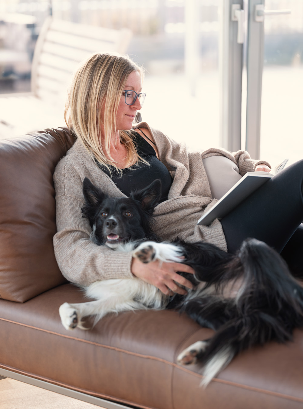 Entspannung auf dem Sofa mit Buch und Hund Entspannung auf dem Sofa mit Buch und Hund