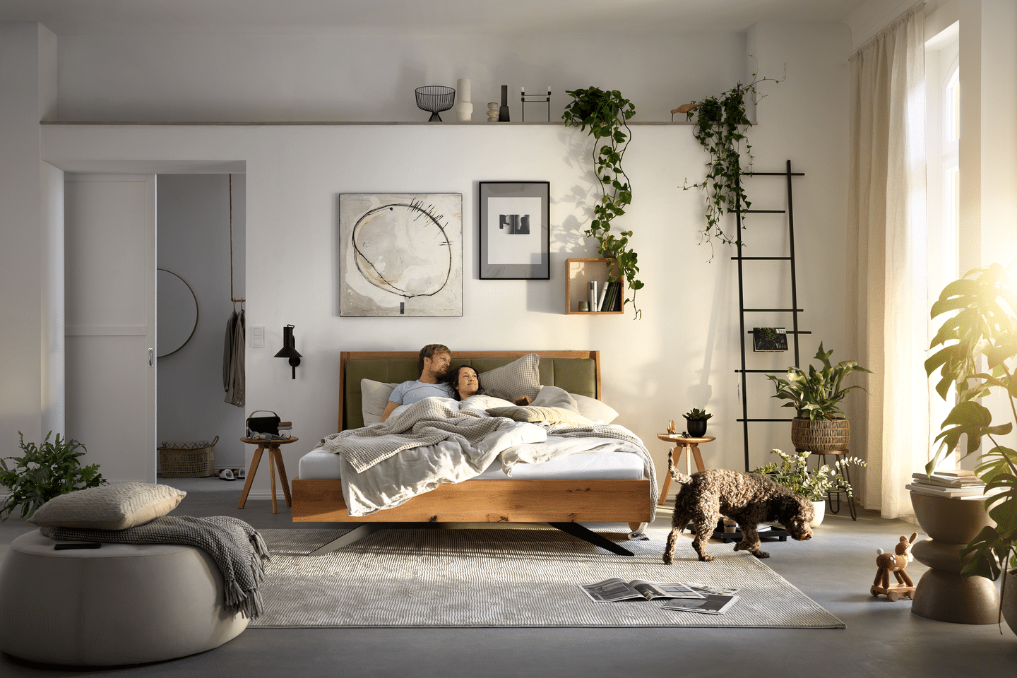 Paar liegt im Bett und die Sonne scheint durch das Fenster