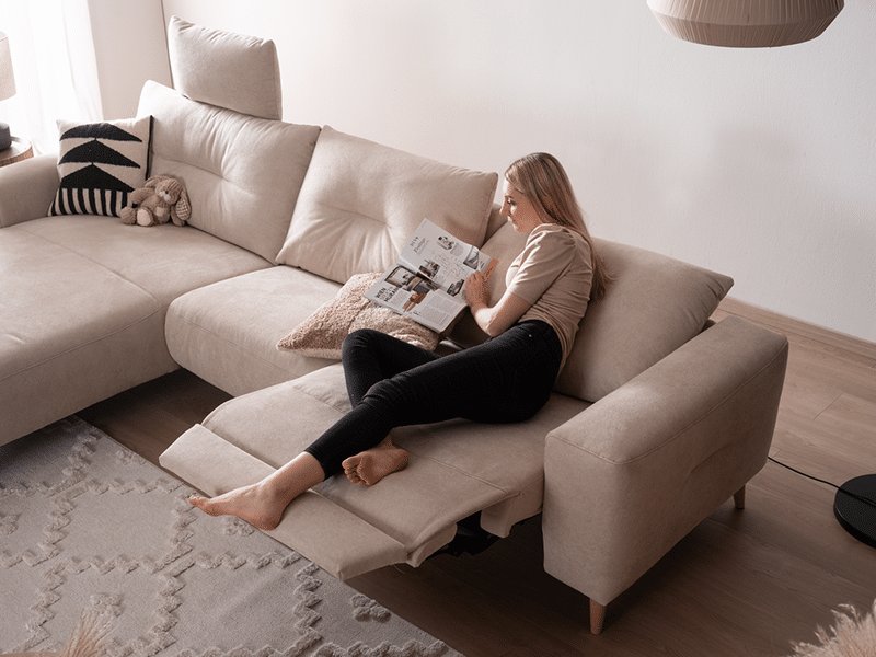 3xl-Alika_800x600px beiges Sofa ALIKA von ADA Möbel mit lesender Frau
