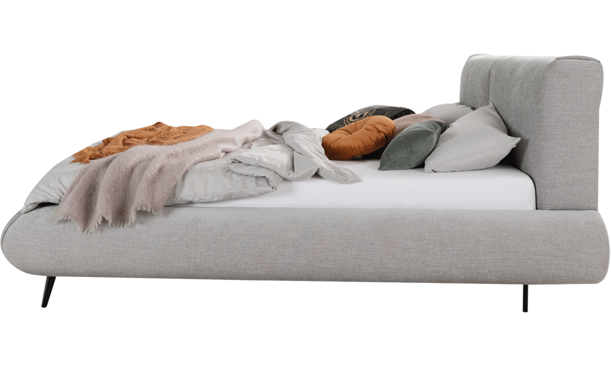 Bett Calmatio mit grauem Stoff, schwarzen Holzfüßen und Naht im Kopfteil