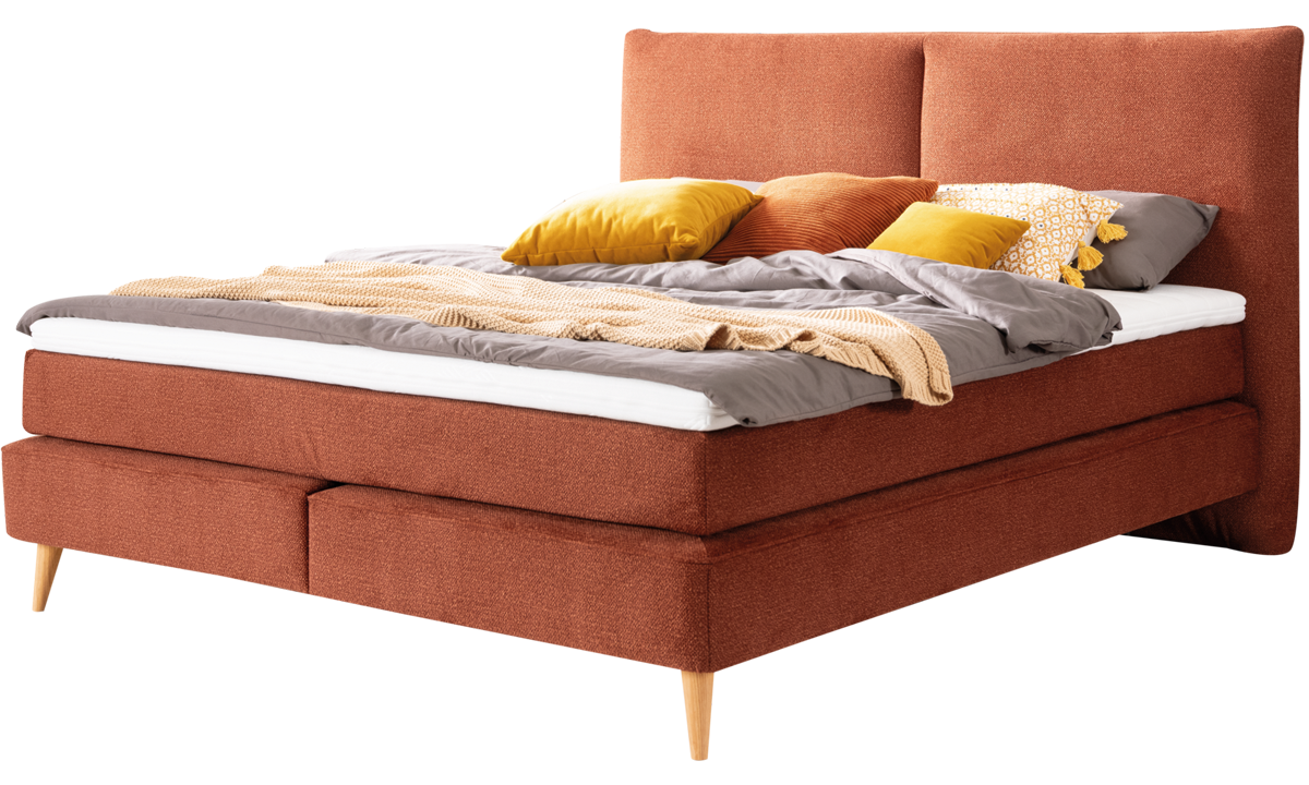 Boxspringbett Neroni mit rostbraunem Stoff und dekoriert